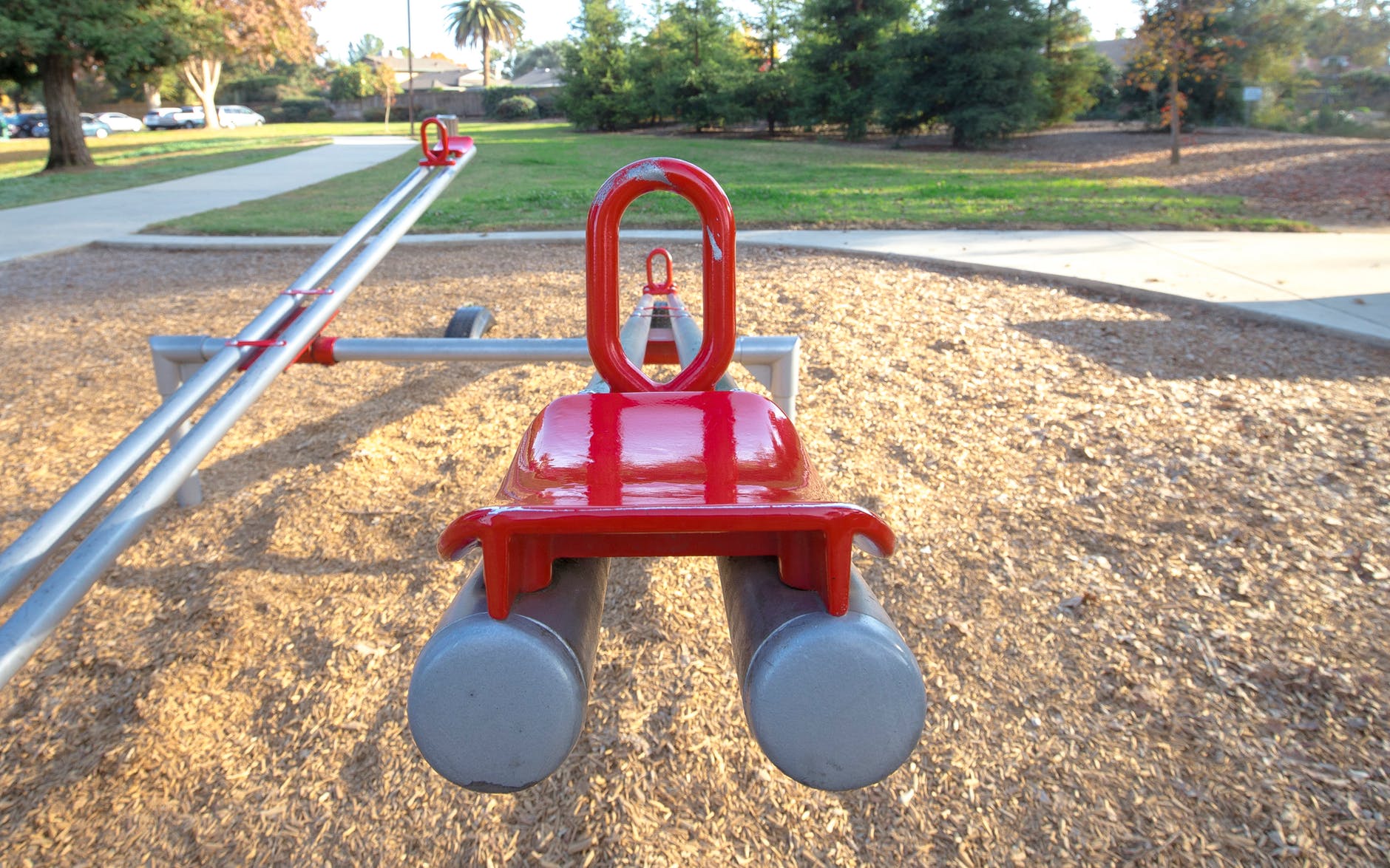 red and gray seesaw in the playground